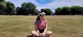 Žena na trávě s VR headsetem