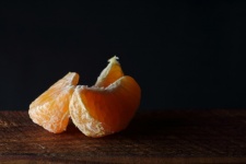 Peeled mandarin wedges on wood