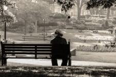 Kvinna sitter ensam på en bänk
