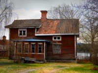 Изношенные красный деревянный дом