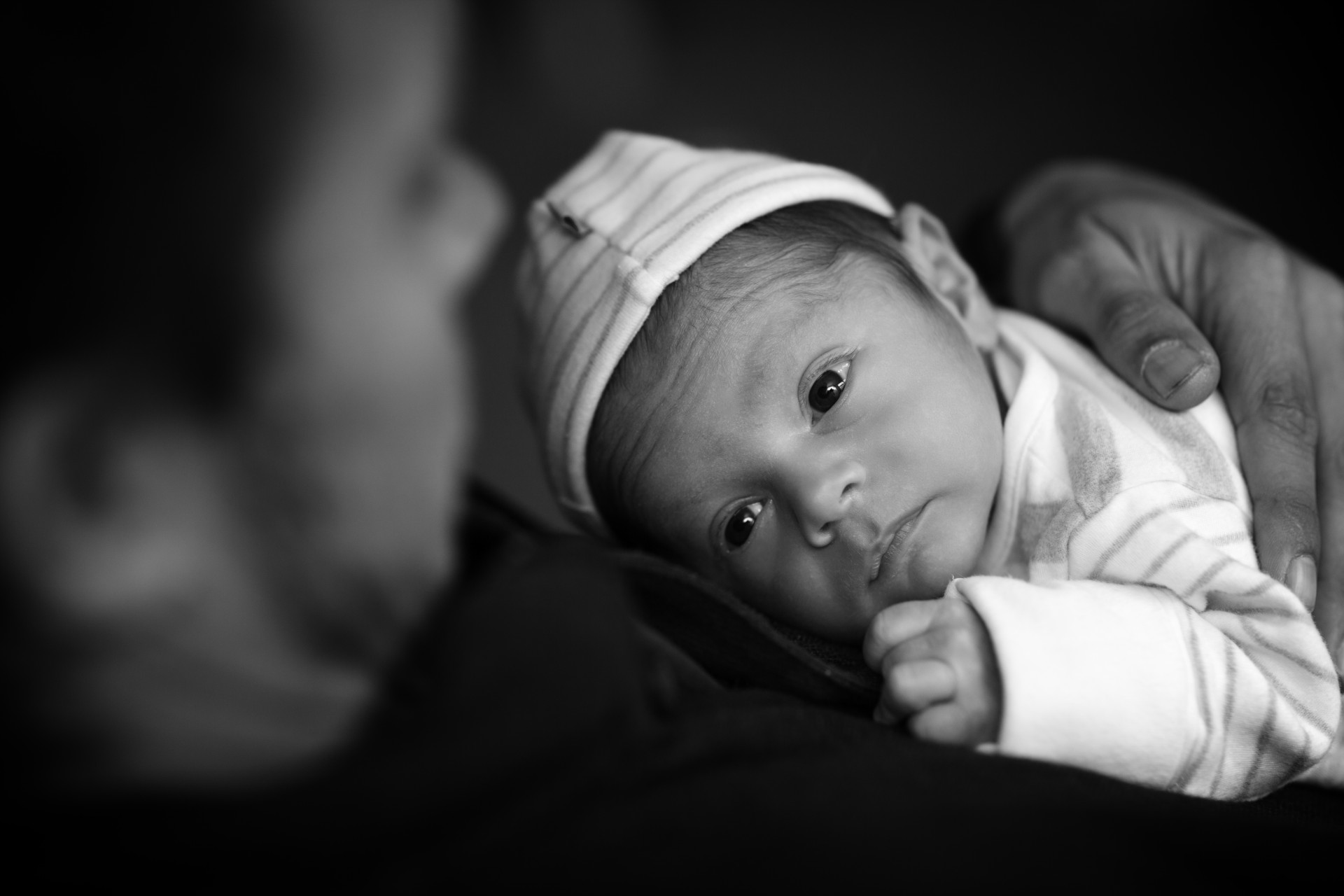 A newborn gazing up at a parent.^[[Image](https://www.publicdomainpictures.net/en/view-image.php?image=54223&picture=man-holding-newborn) is in the public domain]