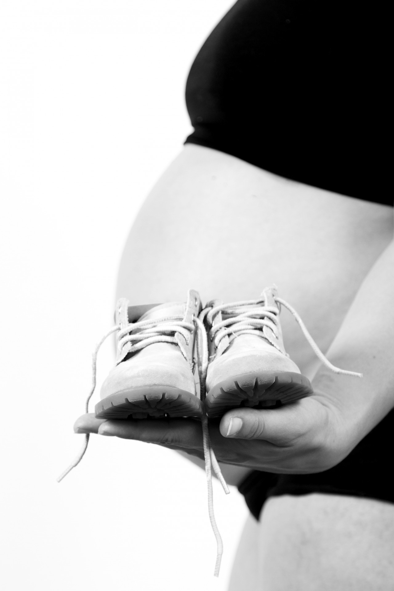Schwangere Frau mit Baby-Schuhe
