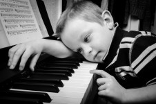 Smutný kluk hraje na klavír