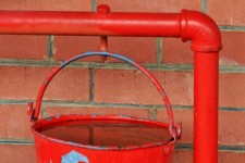 Red fire bucket ready on a rail